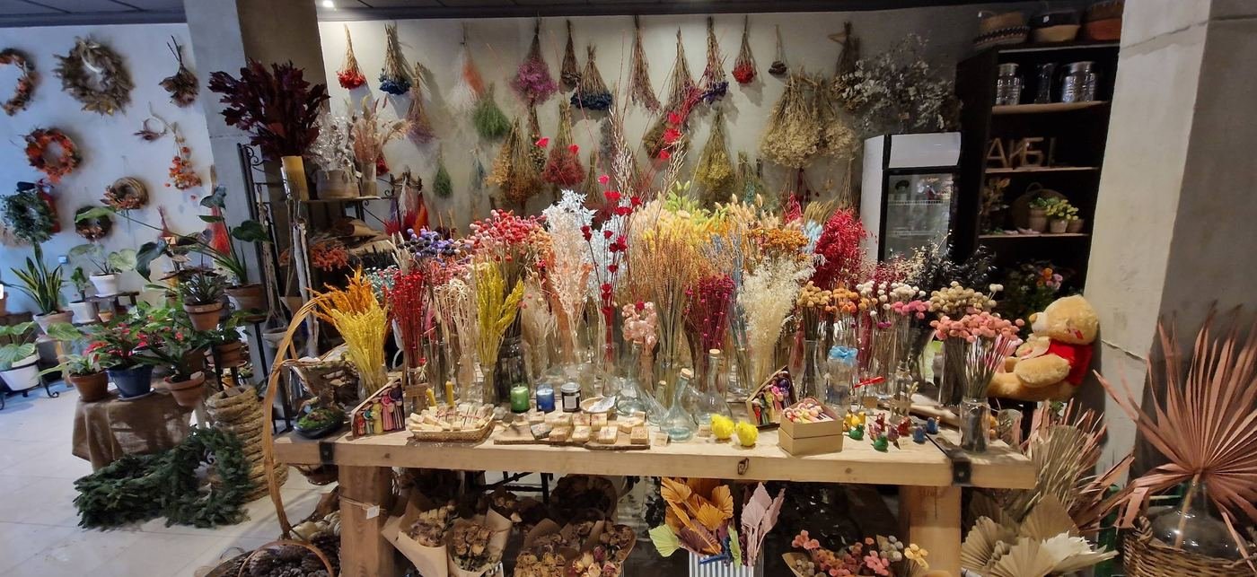 Interior de la tienda repleto de flores secas y plantas