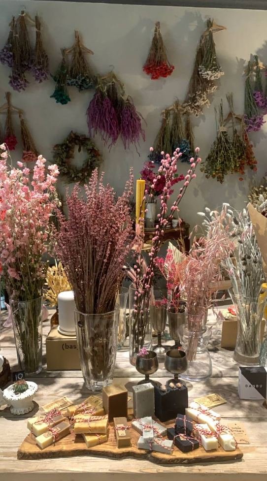 Ramos de flores secas colgando del techo de la tienda